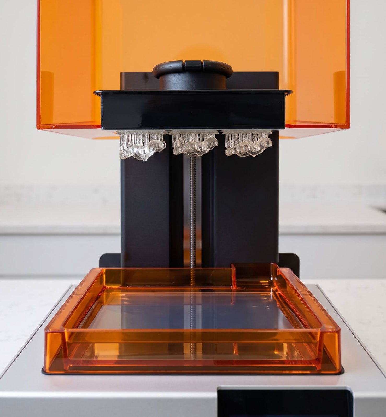 Impressora 3D de resina amb peces dentals acabades d'imprimir