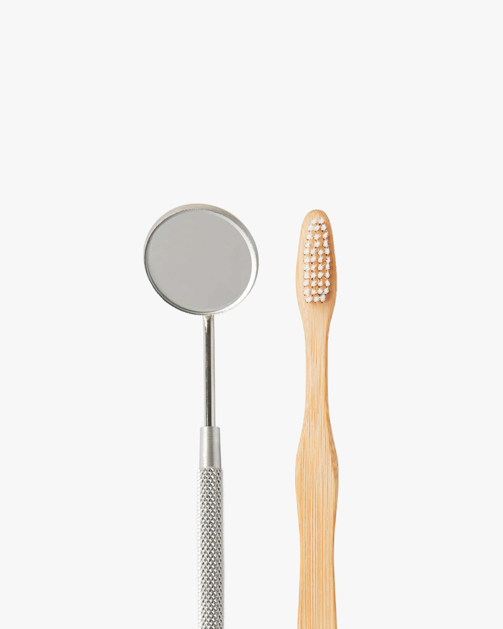 Mirall dental d'exploració sobre fons blanc