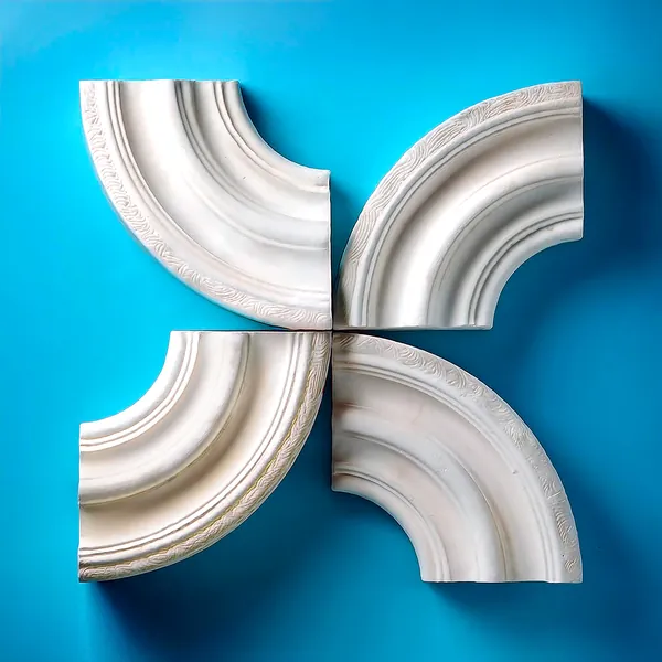 Letter X made of four white plaster moulding pieces on blue