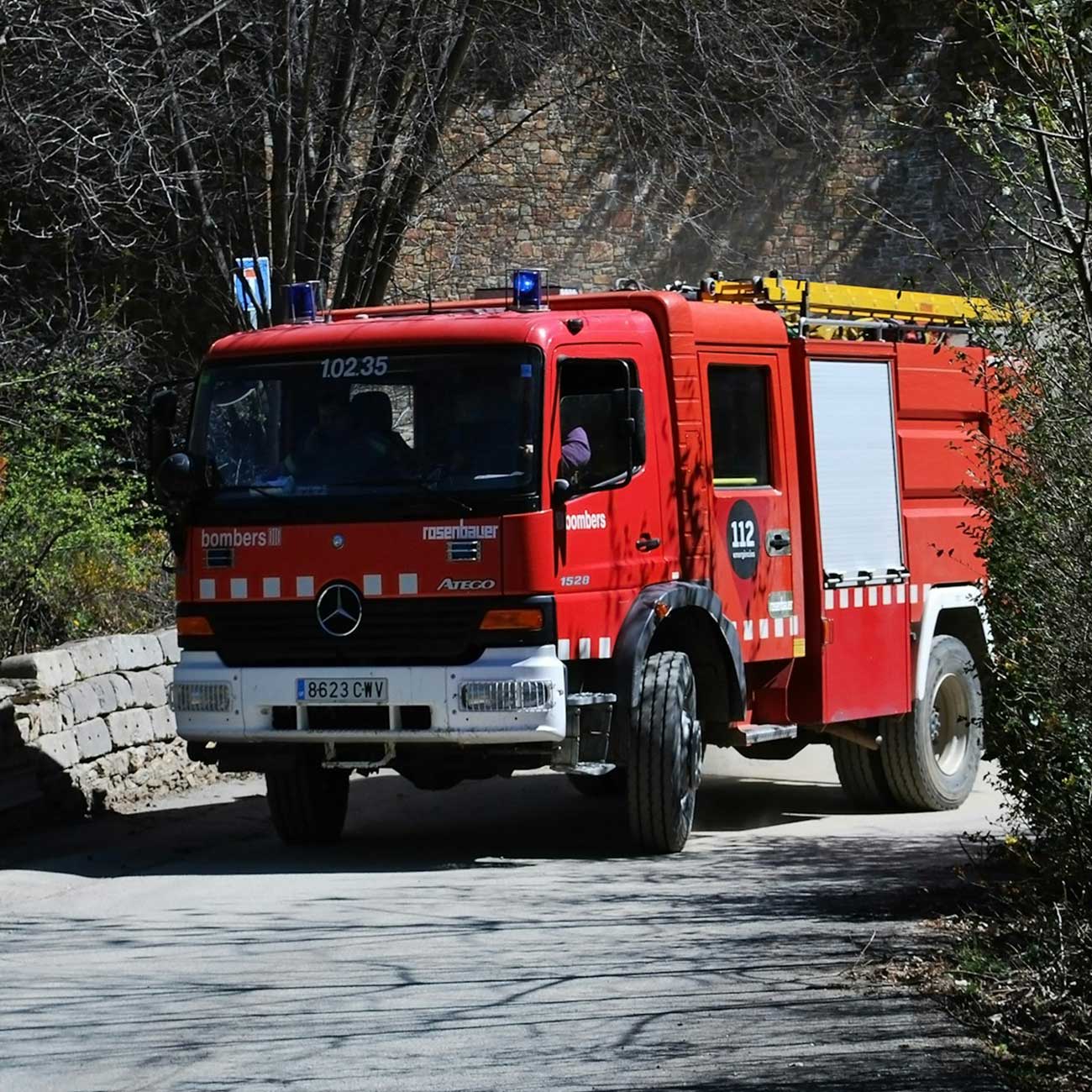 Fire engine driving along a narrow rural road on its way to an intervention