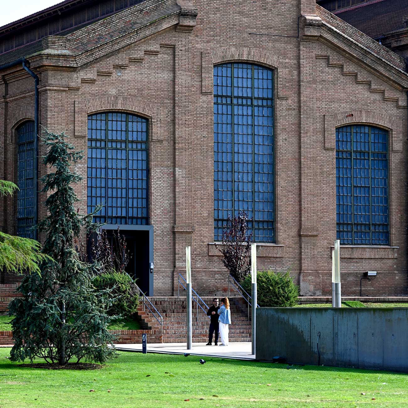 Red-brick façade of the Edifici d'Amargós i Samaranch, the modernist building housing the museum's permanent exhibition, with its symmetric gable and tall arched windows.
