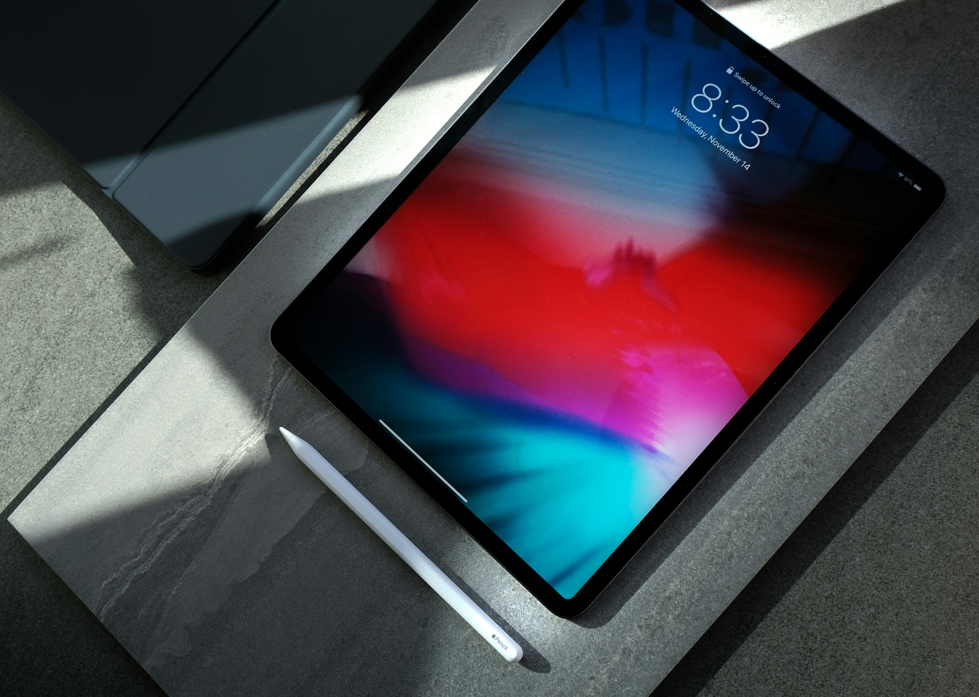 iPad amb la pantalla encesa sobre una superfície fosca